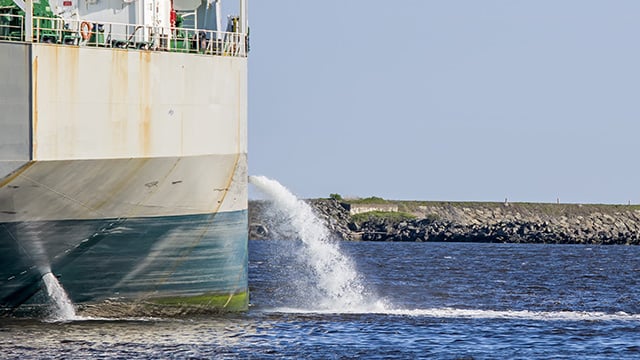 Tanker discharging ballast into the harbor Water flows from the side