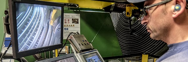 Man monitoring screen in welded spiral heat exchanger workshop